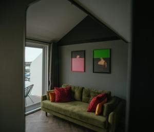 a living room with a green couch and a window at Tiny Floating Home with Marina Views in Brighton & Hove