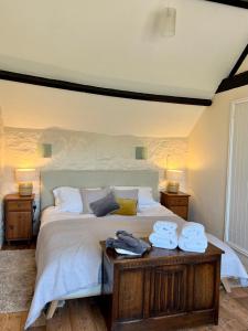 ein Schlafzimmer mit einem großen Bett mit Handtüchern darauf in der Unterkunft Norburton Hall Cottages in Bridport