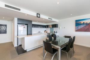 a kitchen and dining room with a glass table and chairs at Lorne Chalet Apartment 40 in Lorne