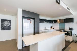 a kitchen with a white counter top and a refrigerator at Lorne Chalet Apartment 40 in Lorne +3 photos
