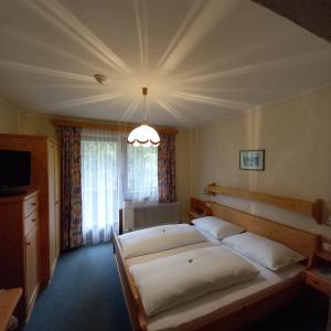 um quarto com 2 camas e um lustre em Hotel Pension Berghof em Schladming