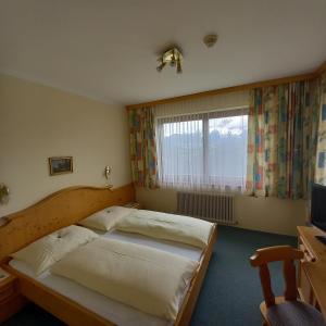 a bedroom with two beds and a window at Hotel Pension Berghof in Schladming