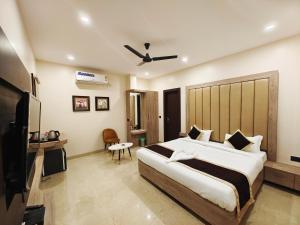 1 dormitorio con 1 cama grande y TV en Radha Residency, en Satna
