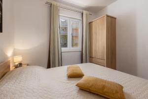 Schlafzimmer mit einem großen weißen Bett und einem Fenster in der Unterkunft HELENA in Rogoznica