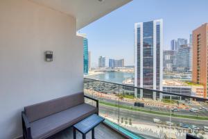 a room with a bench and a view of a city at Urban Studio at MAG 318 Business Bay by Deluxe Holiday Homes in Dubai