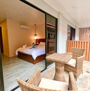 Habitación con cama, mesa y sillas. en Island Princess Resort & Spa Boracay, en Boracay