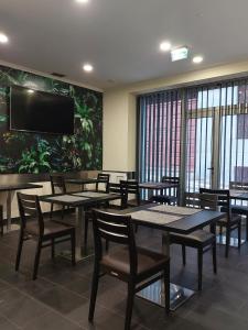 a dining room with tables and chairs and a flat screen tv at São Francisco Accommodation in Funchal