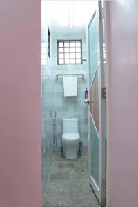 uma casa de banho com um WC branco e uma janela em Wonderful Homestay at Muar em Muar