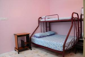 a bedroom with two bunk beds and a table at Wonderful Homestay at Muar in Muar