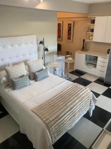 1 dormitorio con 1 cama grande con almohadas y cocina en Home Suite Hout Bay en Ciudad del Cabo