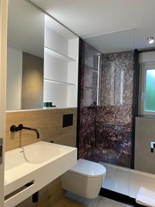 ein Badezimmer mit einem Waschbecken, einem WC und einem Spiegel in der Unterkunft Moselfreude in Cochem