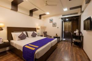 a hotel room with a bed and a desk at Cygnett Inn Ramachandra in Kurmannapalem
