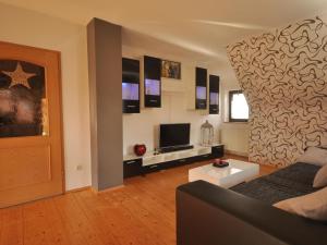 a living room with a couch and a television at Lovely Apartment in Frankenberg with Barbecue in Frankenberg