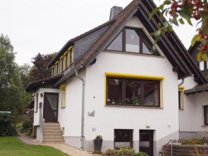 a white house with yellow accents at Lovely Apartment in Frankenberg with Barbecue in Frankenberg