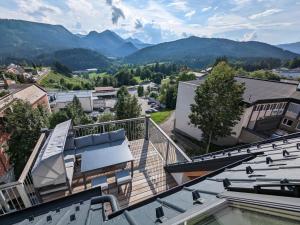 Apartment in Mariazell near ski area في ماريازيل: منظر من سقف مبنى فيه جبال في الخلف