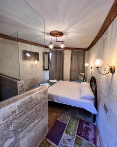 a bedroom with a bed and a stone wall at ROCA CAPPADOCIA in Ürgüp