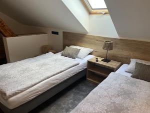 1 dormitorio con 2 camas y mesita de noche con lámpara en Penzion a Restaurace ZÁMECKÁ VRÁTNICA en Vizovice