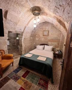 1 dormitorio con 1 cama grande en una habitación de piedra en ROCA CAPPADOCIA, en Ürgüp