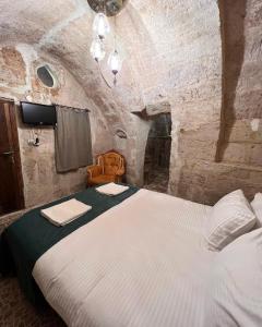 1 dormitorio con 1 cama en una habitación de piedra en ROCA CAPPADOCIA en Urgup