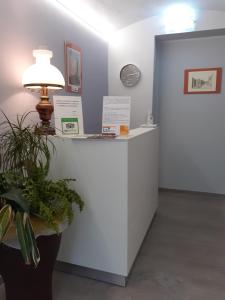 a reception desk with a lamp and a clock at Royal Room & Breakfast in Modena