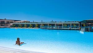 una mujer en bikini en una gran piscina en Giannoulis – Cavo Spada Luxury Sports & Leisure Resort & Spa en Kolymvari
