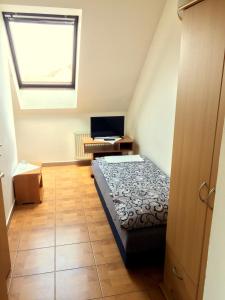 1 dormitorio con 1 cama y escritorio con ordenador portátil en Penzion Xaver, en Blučina