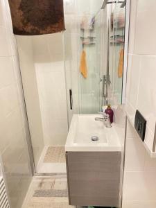 ein weißes Bad mit einem Waschbecken und einer Dusche in der Unterkunft La casa dell'Infanta - Finalborgo in Finale Ligure