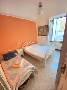 1 Schlafzimmer mit 2 Betten und einem Fenster in der Unterkunft La casa dell'Infanta - Finalborgo in Finale Ligure