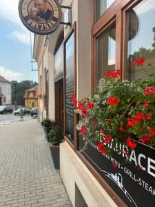 znak na boku budynku z czerwonymi kwiatami w obiekcie Penzion a Restaurace ZÁMECKÁ VRÁTNICA w mieście Vizovice