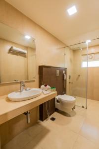 a bathroom with a sink and a toilet at Cygnett Inn Ramachandra in Kurmannapalem