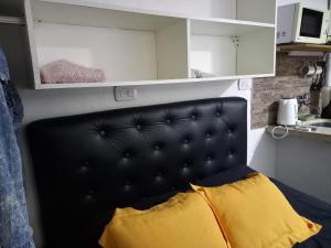 ein schwarzes Kopfteil mit einem gelben Kissen in einem Zimmer in der Unterkunft Rinconada 3 in Las Grutas