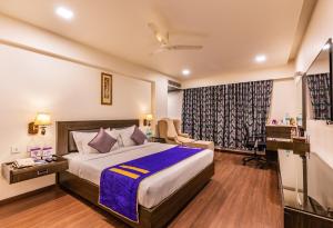 a hotel room with a bed and a desk at Cygnett Inn Ramachandra in Kurmannapalem