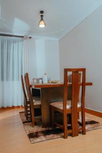 a dining room with a table with chairs and a dining room at Broadbills Haven apartment in Kampala