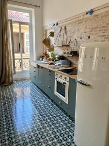 a kitchen with blue cabinets and a white refrigerator at Appartement Haussmannien rue piétonne Opéra in Marseille