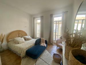 a bedroom with a bed and a blue chair at Appartement Haussmannien rue piétonne Opéra in Marseille