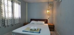 um quarto com uma cama com duas toalhas em Khonesavane Hostel em Luang Prabang