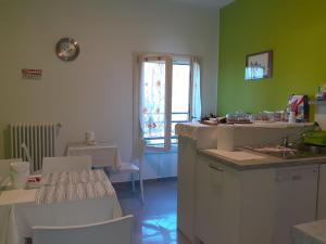 a kitchen with green walls and a table and chairs at Royal Room & Breakfast in Modena