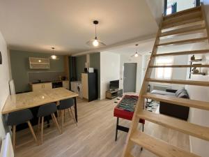 ein Wohnzimmer mit einer Treppe und eine Küche in der Unterkunft Entre terres et mer in Samer