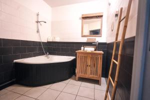 uma casa de banho com uma banheira e um espelho. em Caz Patio, T2 - 4 étoiles, front de mer em Saint-Pierre