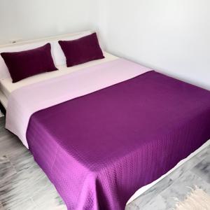 a bedroom with a purple blanket on a bed at Aldea Beach in Castillo de Sabinillas