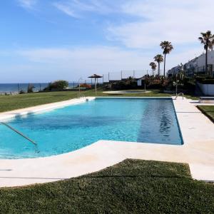 a swimming pool with the ocean in the background at Aldea Beach in Castillo de Sabinillas