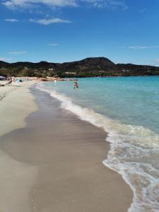 una playa con gente nadando en el agua en Appartamento Bahia Feliz, en Murta Maria