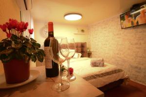 Zimmer mit einer Flasche Wein und zwei Weingläsern in der Unterkunft יחידת דיור עם בריכה in Kiryat Ekron