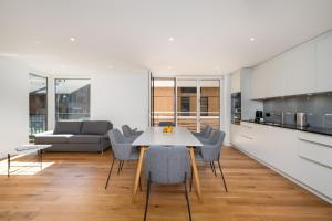 eine Küche und ein Wohnzimmer mit einem Tisch und Stühlen in der Unterkunft Moderne Neubauwohnung in Wilderswil in Wilderswil
