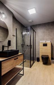 メヘリンキにあるMartinus Apartmentsのバスルーム(黒い洗面台、シャワー付)
