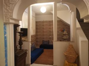 a living room with an archway with a blue couch at Le jardin d'habiba in Rhorm el Alem