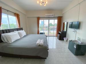 una camera da letto con un letto e due pantofole sopra di Uh Hostel a Bangsaen