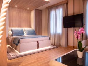 a bedroom with a bed and a flat screen tv at Miramare Suites in Sestri Levante
