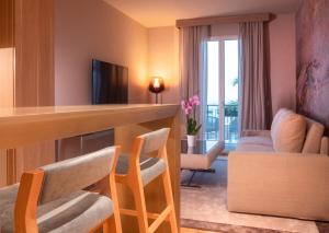 a hotel room with a bar and chairs and a balcony at Miramare Suites in Sestri Levante