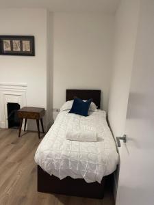 a bedroom with a bed with a blue pillow at 2 Bedroom House next to Slade Green Station in Slades Green